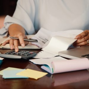 Hands of female entrepreneur working with bills and documents